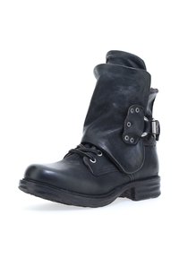 Černá kožená kotníková bota s ohrnutým lemem, šněrováním v přední části a kovovými akcenty na boku. Texturovaný povrch a nízký stohovaný podpatek.