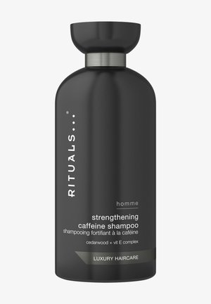 Bouteille de shampooing cylindrique noire avec un capuchon arrondi. Accent en métal argenté sur le col. Texte blanc indiquant les détails du produit et les ingrédients.