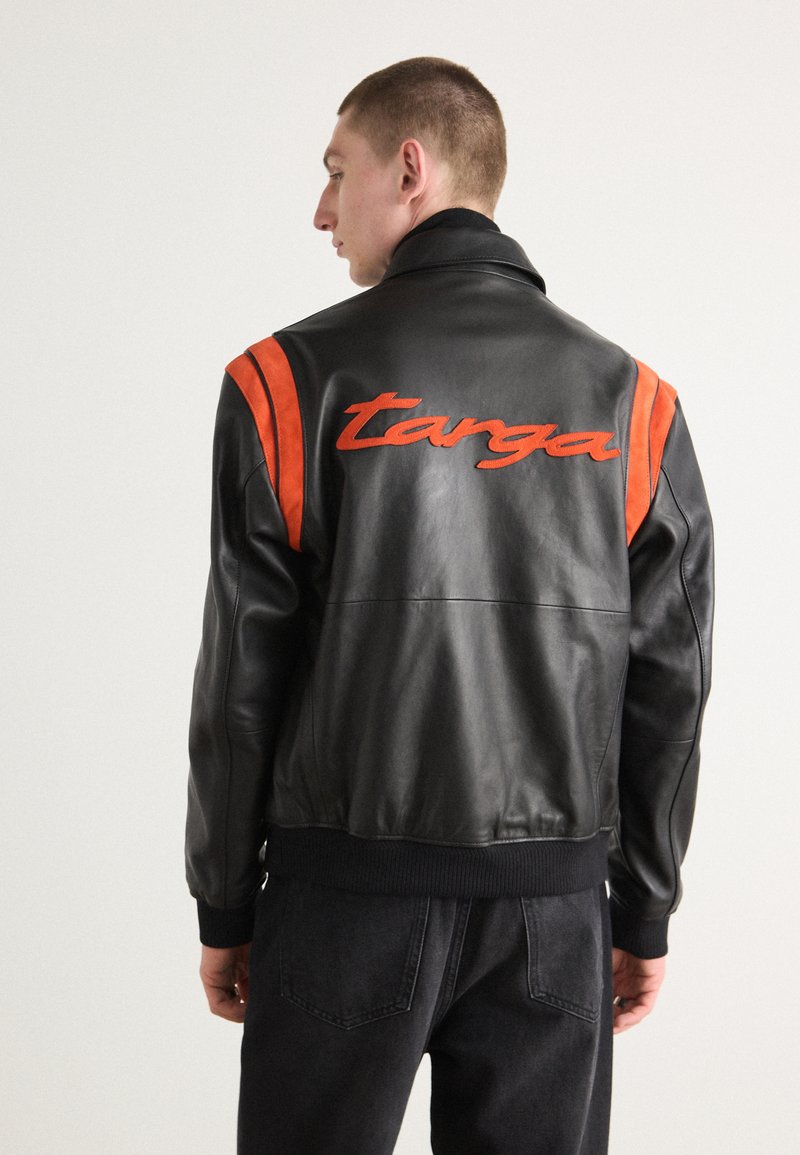 Sort læder bomberjakke med orange ruskindstriber og broderet "targa" logo på ryggen. Har ribbede ærmer og talje.