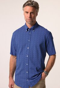 Koszula z krótkim rękawem zapinana na guziki, wykonana z niebieskiej tkaniny, z białym wzorem w kotwice, kołnierzykiem i guzikami z przodu.