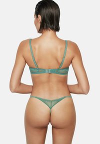 Kant beha en slip set in teal, met dunne bandjes, gaaspanelen en een decoratieve sluiting op de rug, die een ingewikkeld ontwerp toont.