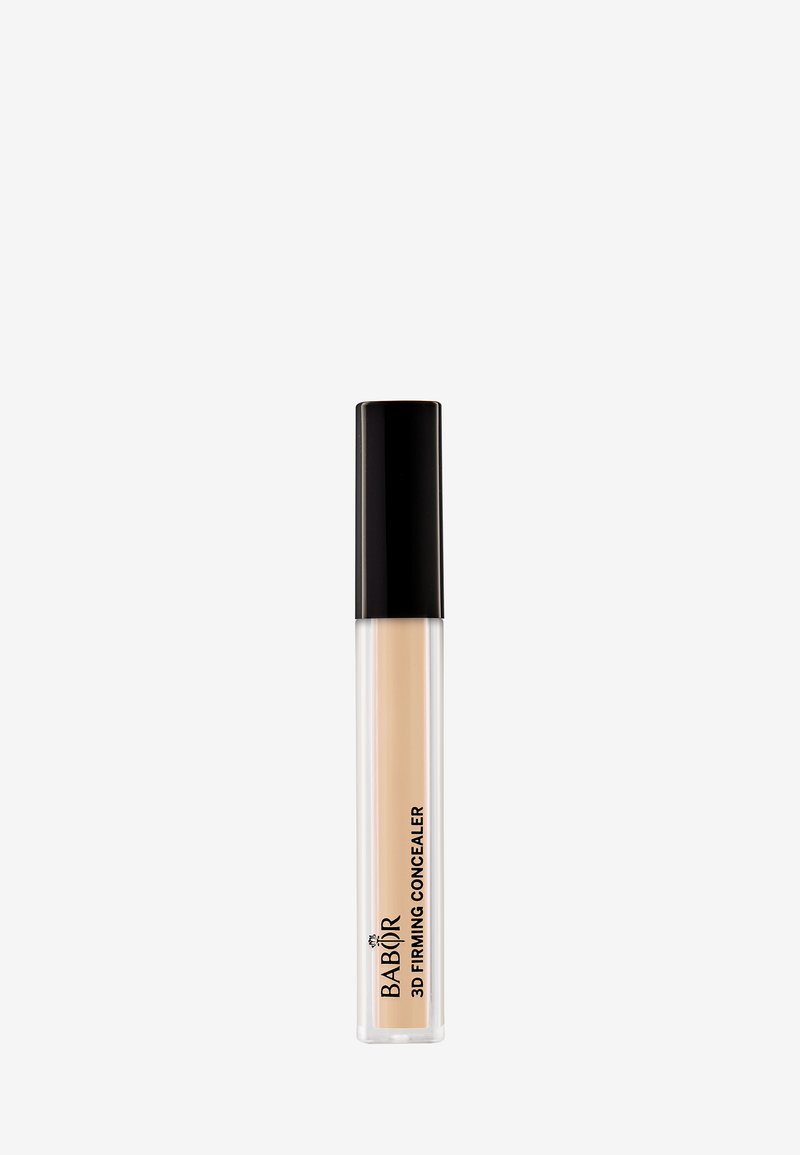 Transparente Tube mit Concealer und schwarzem Deckel, der eine beige Flüssigkeit enthält. Markenlogo auf der Seite des Tubus sichtbar.