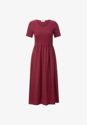 Robe maxi bourgogne avec un haut ajusté et des manches courtes, présentant une jupe froncée et un petit motif brodé sur la poitrine.
