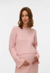 Jasnoróżowy sweter w prążki z długimi rękawami w kształcie dzwonu, w zestawieniu z dopasowaną sukienką podkreślającą zaokrąglony brzuszek. Miękka dzianina.