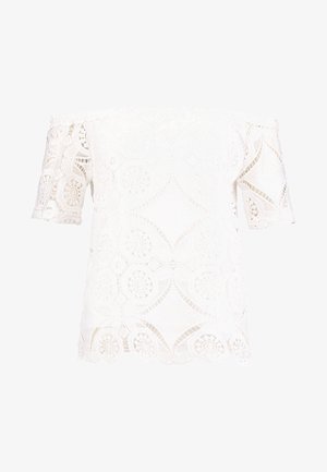 Haut blanc à épaules dénudées en dentelle avec des motifs floraux. Manches courtes et détail de bord festonné. Texture légère et transparente.