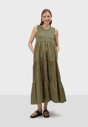 Robe sans manches couleur olive avec un design à étages, fabriquée dans un tissu lisse. Présente un col arrondi et deux poches latérales.