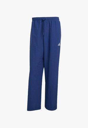 Pantalones deportivos azul marino de tejido ligero, con una cintura elástica y cordón de ajuste, y un logo de Adidas en la pierna izquierda.