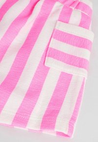 Tissu rayé rose et blanc avec un tissage texturé, doté d'une poche plaquée sur un côté. Les rayures ont une largeur égale.