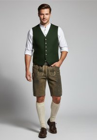 Grüne Weste mit silbernen Knöpfen, weißes Hemd mit Kragen, braune Lederhosen mit gelben Akzenten, crèmefarbene knielange Socken und dunkle Schuhe.
