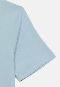 T-shirt à manches courtes bleu clair en tissu doux, avec un design uni et un ourlet soigneusement cousu, offrant une texture lisse.