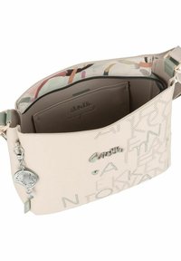 Helle Beige Schultertasche aus strukturiertem Leder, mit einem geprägten Design, silberner Hardware und einem farbenfrohen, gemusterten Innenraum.