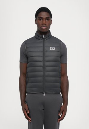 Grau gesteppte Weste mit hohem Kragen, Frontreißverschluss und gesticktem Logo. Verfügt über ein gesteppte Design, leichtes Material und seitliche Taschen.
