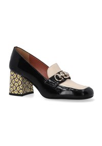Zwarte en beige leren hoge hak schoenen met een glanzende afwerking, voorzien van een decoratieve gesp en een geel-zwart blokhak met patroon.