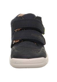 Marineblaue Schuhe mit einer glatten, strukturierten Oberfläche, ausgestattet mit zwei Klettverschlüssen und einer gepolsterten Sohle. Verstärkte Zehenpartie und kontrastierende Nähte.