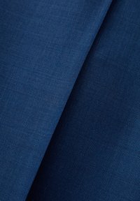 Marineblauwe stof met een gladde, gestructureerde oppervlakte, voorzien van een geweven patroon. Twee lagen zijn zichtbaar, wat diepte en uniformiteit toont.