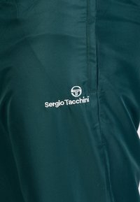 Groene sportieve shorts gemaakt van gestructureerde stof. Bevat een wit "Sergio Tacchini" logo en een eenvoudig ontwerp zonder versieringen.