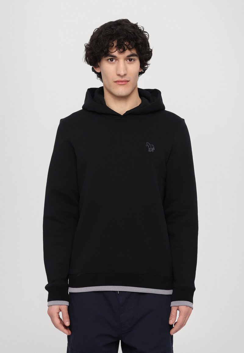 Black hoodie made of cotton-blend material with a front pocket, ribbed cuffs, and a gray underlayer at the hem. Features a small logo on the chest.