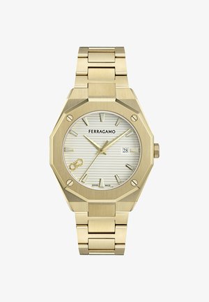 Zelta Ferragamo pulkstenis ar astoņstūra formas rāmi, sudraba svītrains ciparnīca, zelta stundu atzīmes, datuma logs pie plkst. 3 un metāla saites siksniņa.