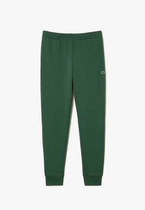 Pantalon de jogging fuselé vert foncé avec taille élastique et petit logo crocodile sur la partie supérieure de la cuisse, chevilles resserrées.