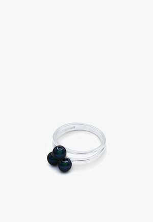 Bague argentée à double bande avec trois petites perles noires brillantes regroupées sur le dessus, fond blanc uni.