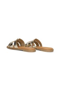 Gouden metalen sandalen met gekruiste banden, gestructureerd oppervlak en platte bruine zool. Bevat decoratieve cirkelvormige studs op de banden.