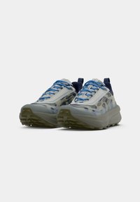 Leichte Sportschuhe mit einem Obermaterial aus Mesh, ausgestattet mit grauen und blauen Camouflage-Mustern, blauen Schnürsenkeln und einer dicken, gepolsterten Sohle.