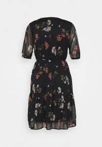 Robe courte noire transparente à manches courtes, taille élastique, ourlet à volants et imprimé floral dans les tons blanc, rose et vert, vue de dos.