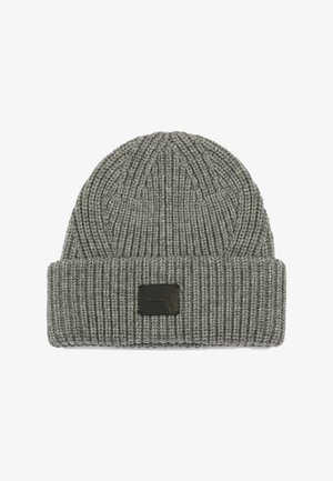 Bonnet en tricot côtelé gris avec un large revers et une étiquette en cuir noir carrée à l'avant. Le matériau texturé apporte chaleur et style.