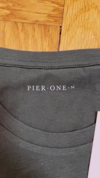 Dark gray shirt featuring a ribbed round neckline. The brand name "PIER•ONE" is printed in white on the back.