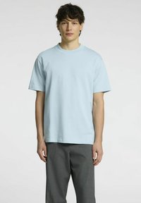 Šviesiai mėlynas trumpomis rankovėmis marškinėliai, pagaminti iš minkštos medvilnės. Sukurtas su apvalia iškirpte ir laisvu siluetu. Derinama su pilkais kelnėmis.