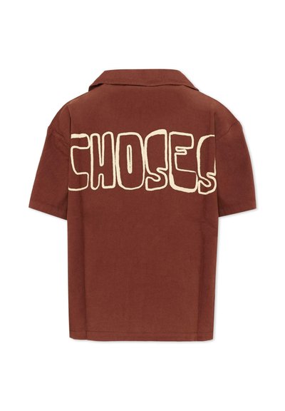 Maglietta marrone a maniche corte con colletto, con grande testo distorto color avorio "CHOSES" sul retro superiore.