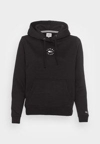 Černá mikina s kapucí na šňůrku, přední kapsou a kruhovým bílým logem. Vyrobena z měkké tkaniny se žebrovan�ými manžetami a lemem.