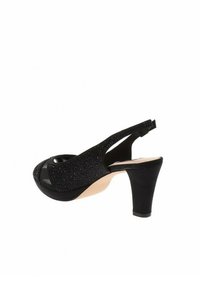 Scarpa nera con cinturino alla caviglia, apertura a punta, upper texturizzato e tacco alto e spesso. Fodera interna liscia con soletta beige.