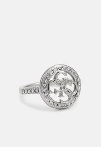 Silver ring med cirkulär design, med en stiliserad logotyp i mitten och prydnader av små klara rhinestones längs ringskenan.