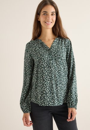 Groene blouse met knopen, v-hals, lange mouwen en een abstract patroon in verschillende tinten groen en beige. Zachte, vloeiende stof.
