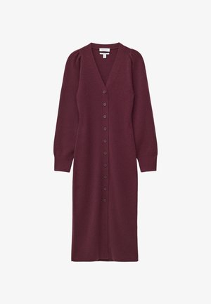 Mørkebrun knælang strikket kjole med V-udskæring, lange ærmer og knaplukning foran. Har ribbede mansjetter og en tætsiddende talje.