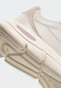 Semelle et côté de basket en cuir beige, avec une semelle extérieure texturée et le logo "Cloudfoam Flex" sur le panneau de la semelle intermédiaire.