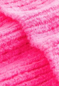 Helles pink, flauschiges Material mit einem strukturierten Rippenmuster. Die Oberfläche wirkt weich und leicht flauschig, mit unterschiedlichen Garnstärken.