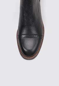 Black leather ankle boot with a smooth toe cap, textured upper, and decorative stitched band across the midsection, featuring a brown sole.