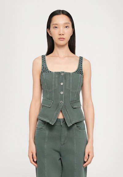 Πράσινο denim γιλέκο με τετράγωνη λαιμόκοψη, με στρατηγές ώμους με καρφιά, μπροστινές τσέπες και κλείσιμο με κουμπί, συνδυασμένο με ταιριαστά παντελόνια.