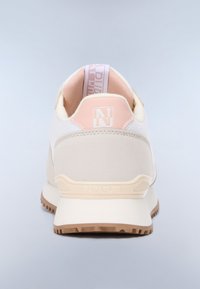 Vue arrière d'une basket blanche et beige avec des accents roses, une languette de tirage marquée et une semelle en caoutchouc marron texturée.