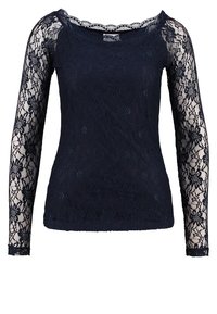 Haut manches longues bleu marine en dentelle avec motifs floraux. Manches en dentelle transparente, encolure ronde et silhouette ajustée.