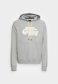 Sweat à capuche gris en mélange de coton, avec une poche avant, un logo Jumpman noir et blanc, et une doublure de capuche texturée avec cordons de serrage.