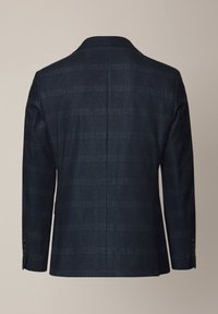 Granatowa marynarka w kratę o dopasowanym kroju, z wyraźnie zarysowanymi ramionami i rozcięciem z tyłu. Ozdobiona subtelnymi czerwonymi i jasnoniebieskimi liniami. Gładka tekstura materiału.