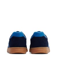 Navy blue suede sneakers with blue accents, rubber sole, padded collar, and contrasting light blue details on the heel and sides.