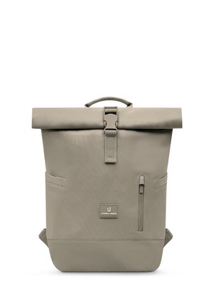 Grauer Rolltop-Rucksack mit Frontschnalle, vertikaler Reißverschlusstasche, Seitentaschen, oberem Griff und "Johnny Urban" Logo-Aufnäher.