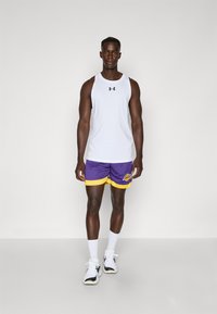 Tricou sportiv fără mâneci alb, cu logo negru, pantaloni scurți de baschet purpurii și galbeni și pantofi sport albi cu accente negre.