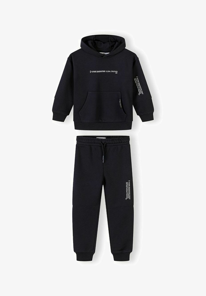 Sweat à capuche noir avec poche avant et pantalon de jogging assorti, tous deux ornés de texte blanc imprimé sur la poitrine, la manche et la jambe.