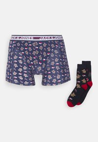 Marineblaue Boxershorts mit Lebkuchenmuster, elastischer Bund mit dem Aufdruck "JACK & JONES". Schwarze Socken mit Lebkuchendesign und roten Akzenten.