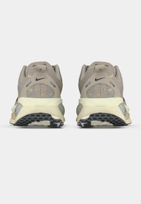 Φωτεινά μπεζ αθλητικά παπούτσια με υφασμάτινη επιφάνεια, αντανακλαστικές λεπτομέρειες και μαλακές σόλες. Διαθέτουν μαύρη λαστιχένια εξωτερική σόλα για καλύτερη πρόσφυση.